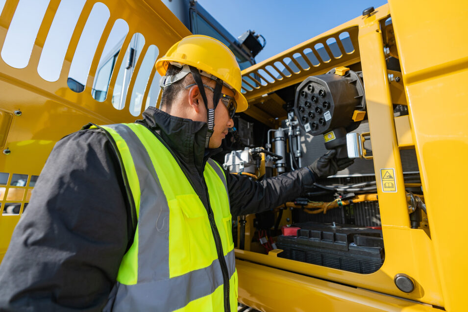 Man checking the inner workings of a Cat machine