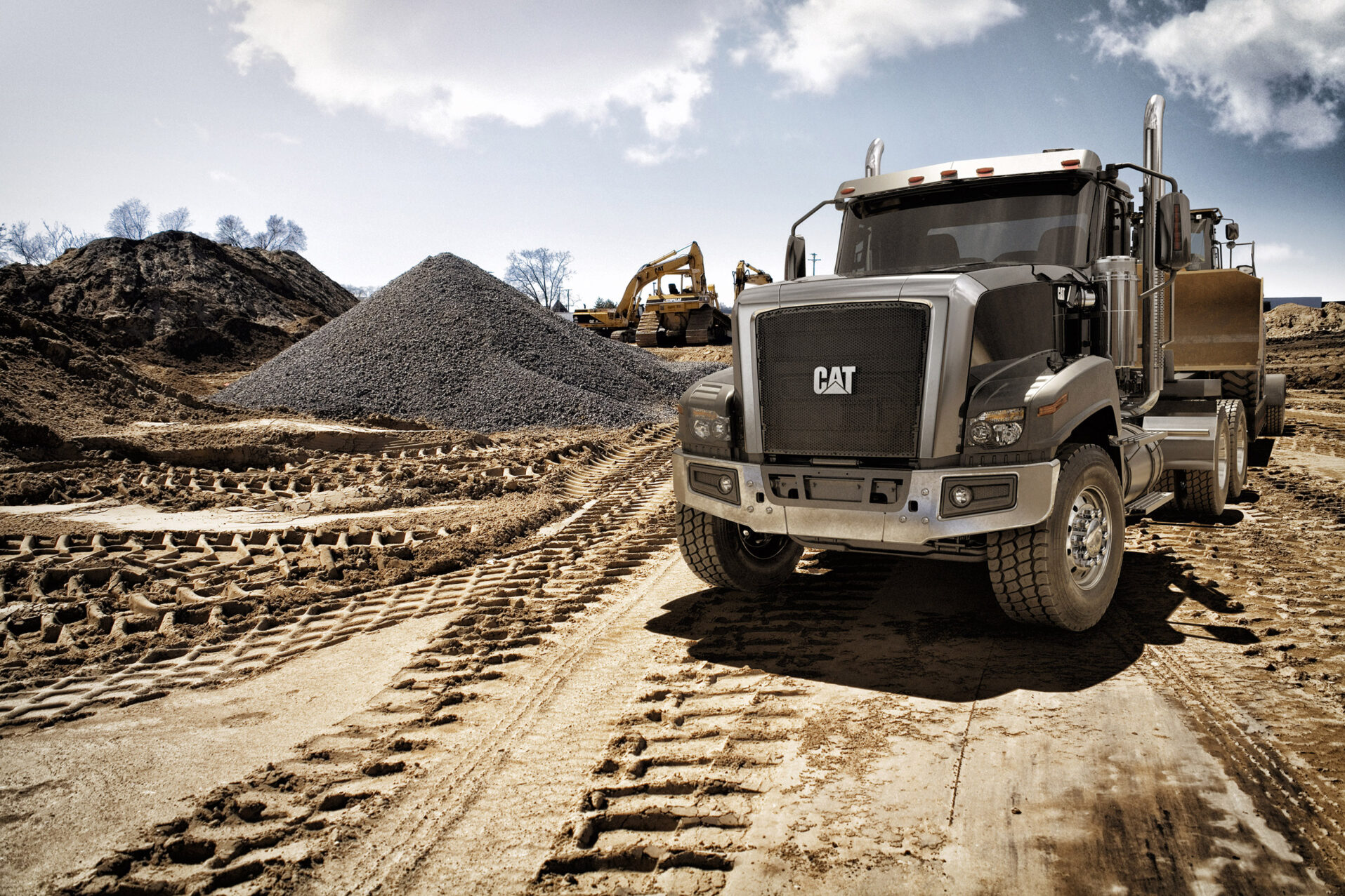 Cat truck surrounded by piles of dirt on a construction scene