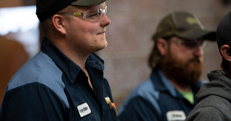 Group of men looking in the same direction and appear to be listening to someone out of view.