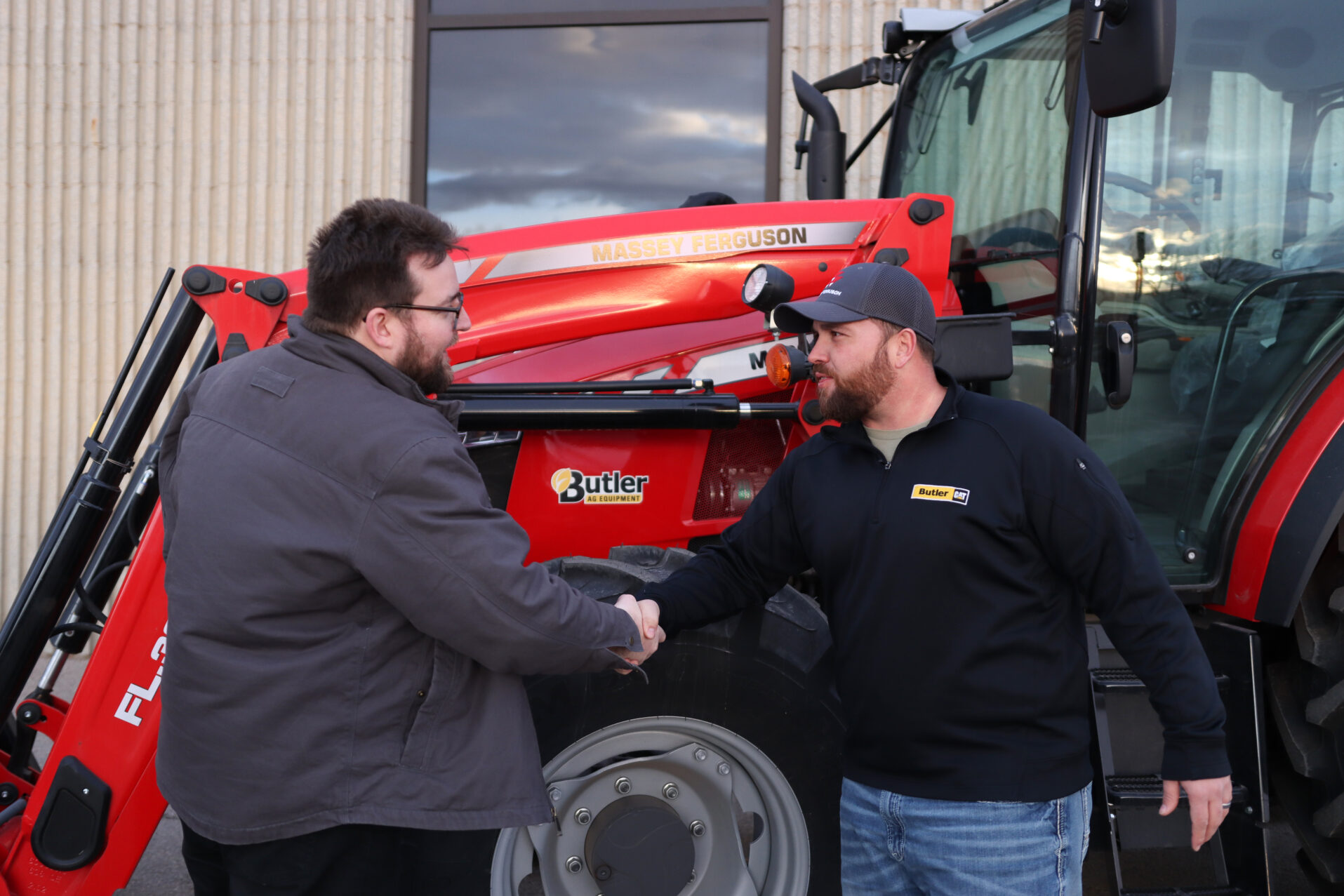 Two men shaking hands in front of Butler equipment.